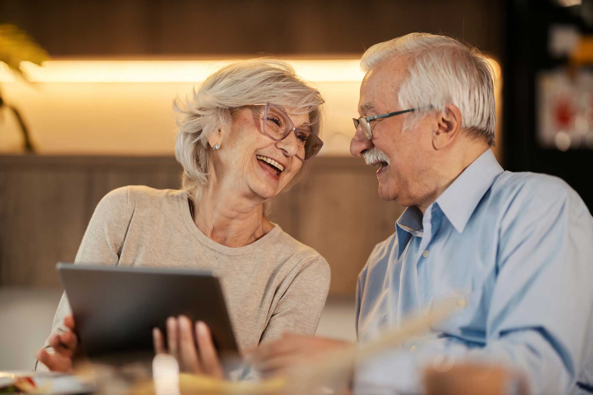 cheerful-senior-couple-laughing-at-dining-table